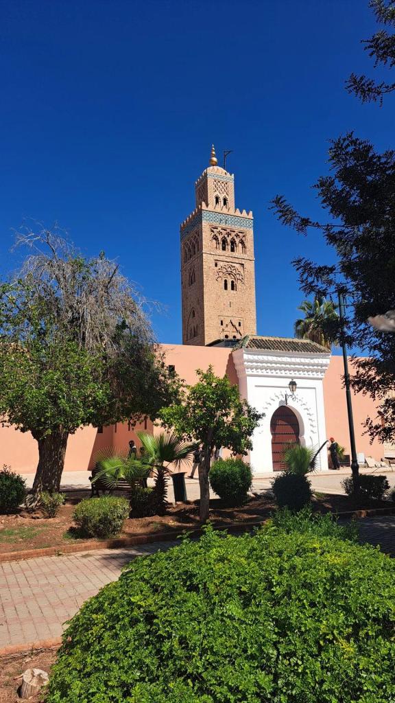 The tall, ornate sandstone minaret of the Koutoubia Mosque in Marrakesh against a clear blue sky.
