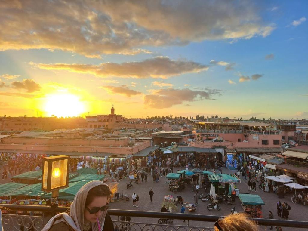 Golden sunset view overlooking a busy, crowded square in the Marrakesh Medina.